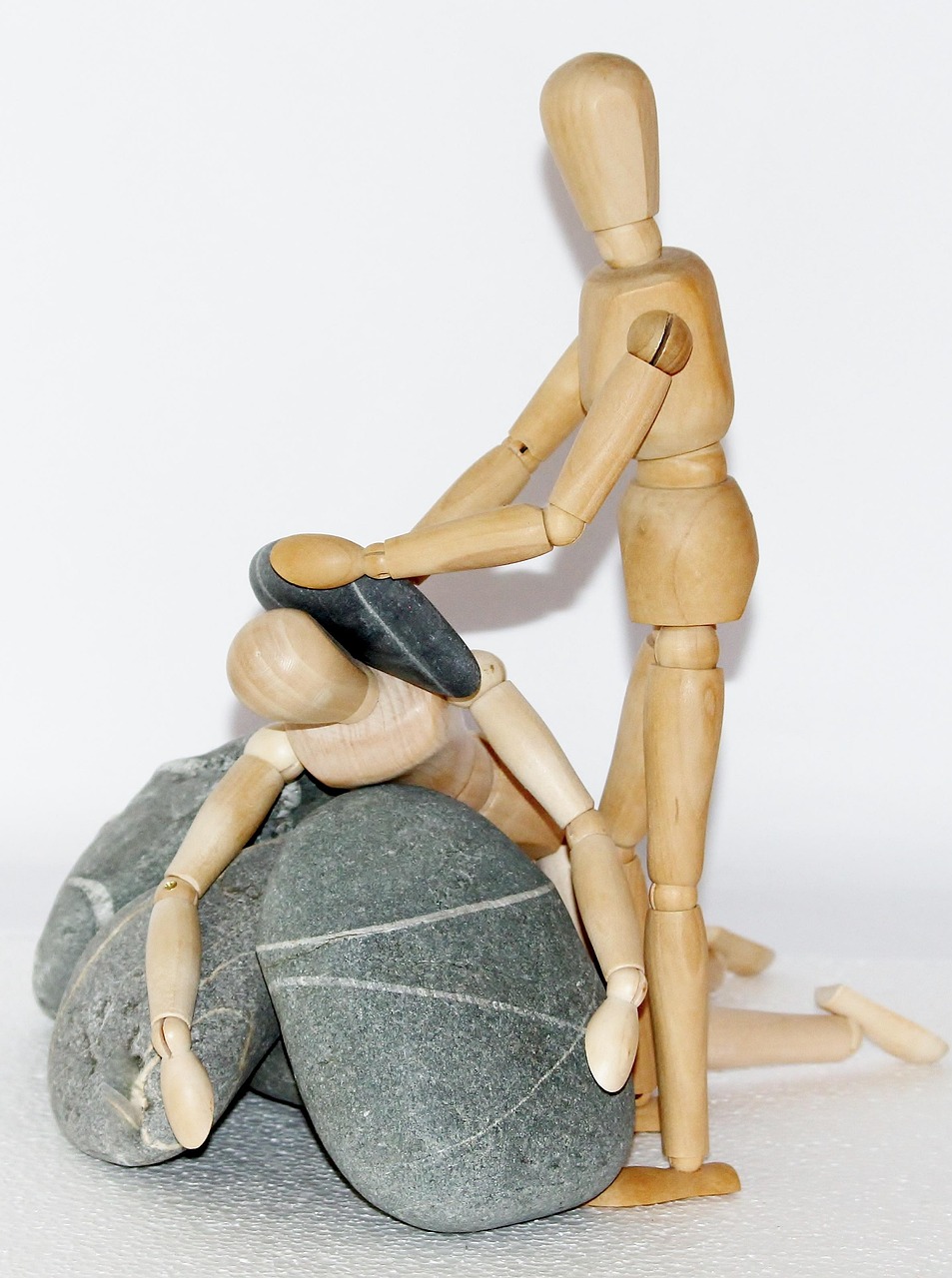 Wooden figures arranged in a supportive pose